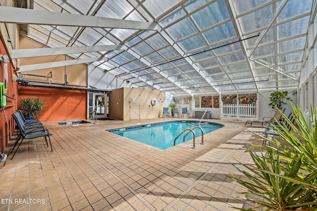 pool with glass enclosure, a patio area, and fence