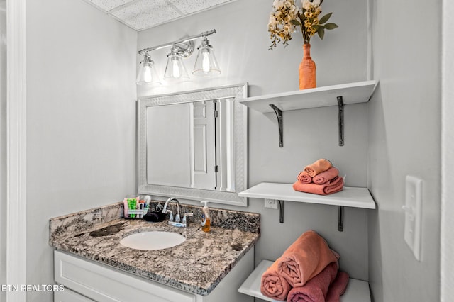 bathroom featuring a drop ceiling and vanity