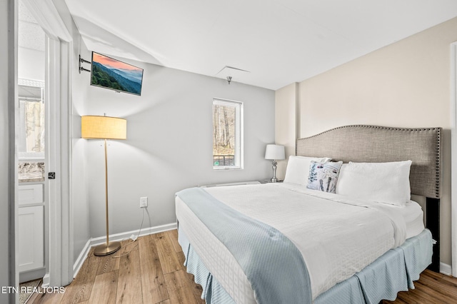 bedroom with baseboards and wood finished floors