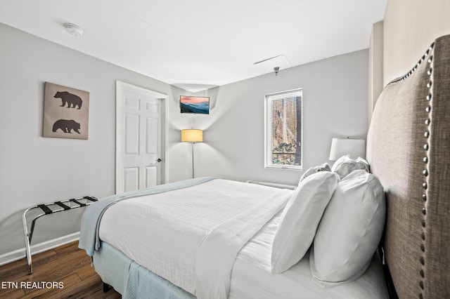 bedroom featuring baseboards and wood finished floors