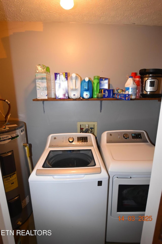 laundry area with laundry area, a textured ceiling, water heater, and washing machine and clothes dryer