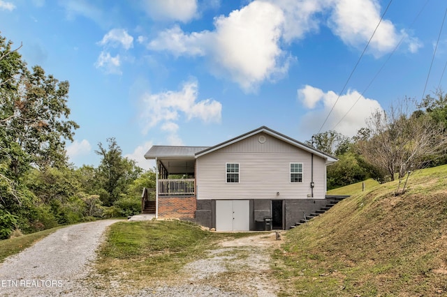 view of home's exterior featuring driveway, stairs, and a yard