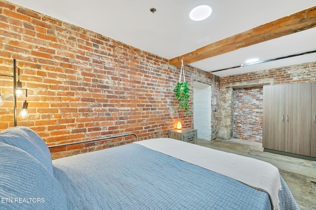 bedroom featuring beam ceiling, concrete flooring, and brick wall