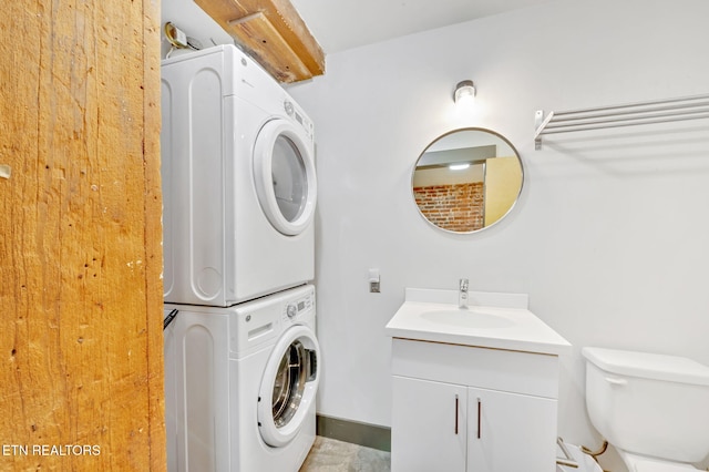 washroom featuring a sink, laundry area, and stacked washer / dryer