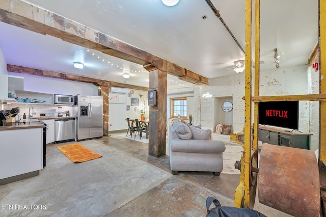 living area with beamed ceiling and ceiling fan