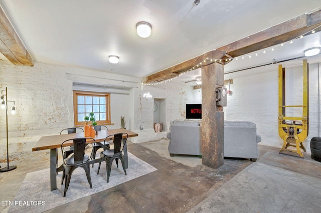 dining space with a fireplace and concrete floors