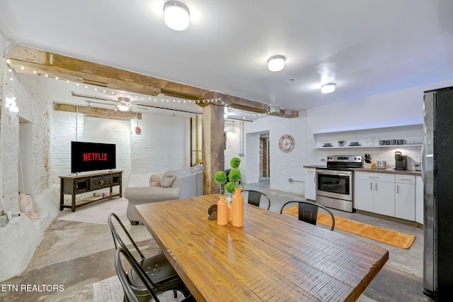 dining space featuring a fireplace and unfinished concrete floors