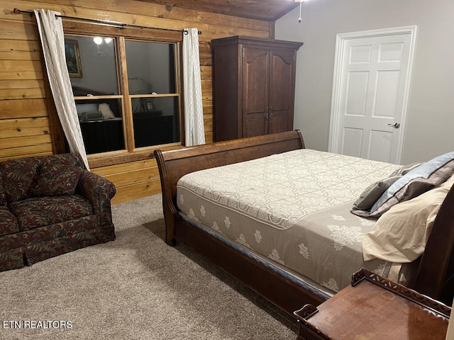 bedroom with wood walls, lofted ceiling, and carpet