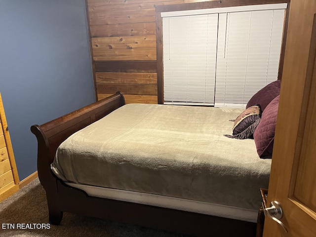 carpeted bedroom with wood walls