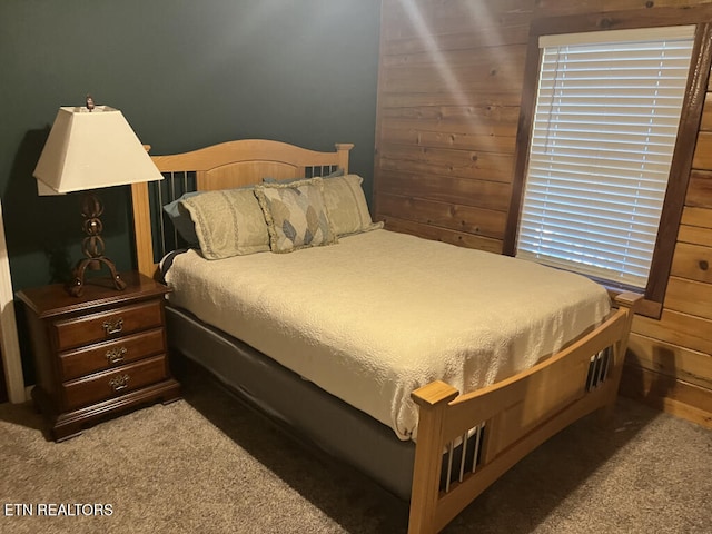 bedroom with wood walls and carpet floors