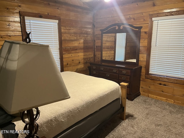 carpeted bedroom featuring wooden walls