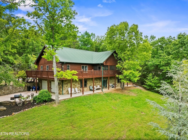 3725 Island View Rd, Sevierville, TN 37876 - rear view of house featuring an attached garage, stone siding, a yard, a patio, and a wooden deck