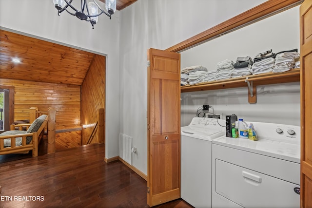 3725 Island View Rd, Sevierville, TN 37876 - laundry room with dark wood-style flooring, visible vents, wooden walls, washer and clothes dryer, and laundry area