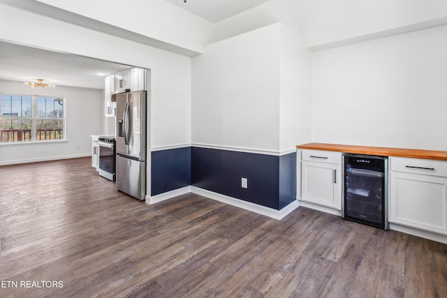 kitchen featuring beverage cooler, a notable chandelier, white cabinets, stainless steel appliances, and wood counters