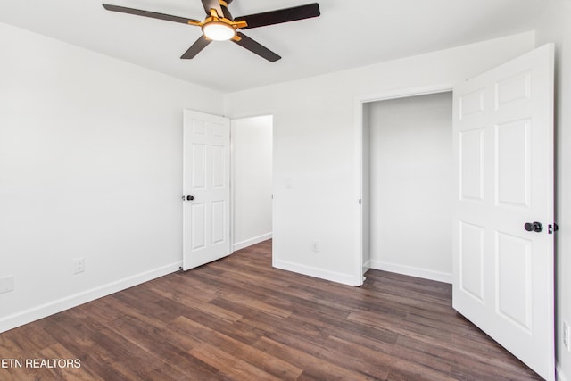 unfurnished bedroom featuring baseboards, dark wood-style flooring, and ceiling fan