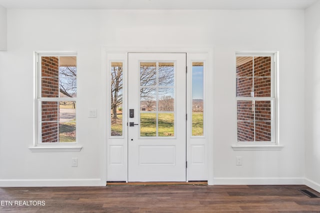 doorway featuring wood finished floors, visible vents, and baseboards