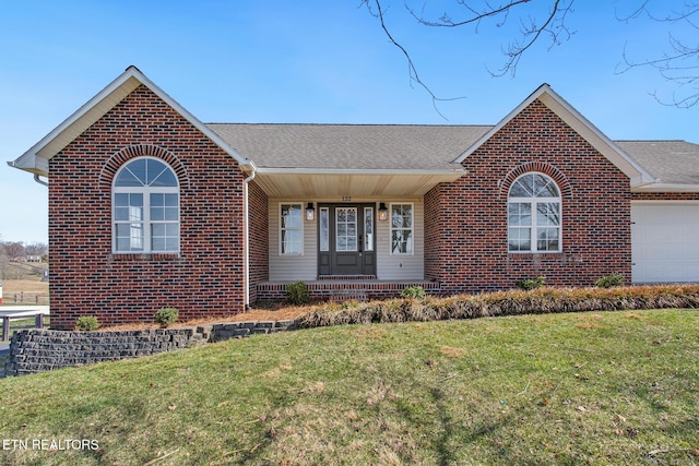 ranch-style house with brick siding, a front lawn, and a shingled roof