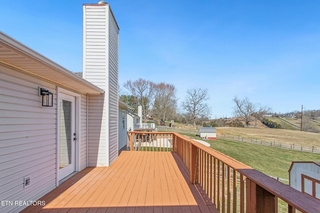 deck featuring an outdoor structure, a yard, and a shed