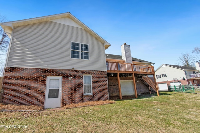 rear view of house with a yard, brick siding, a wooden deck, and stairs