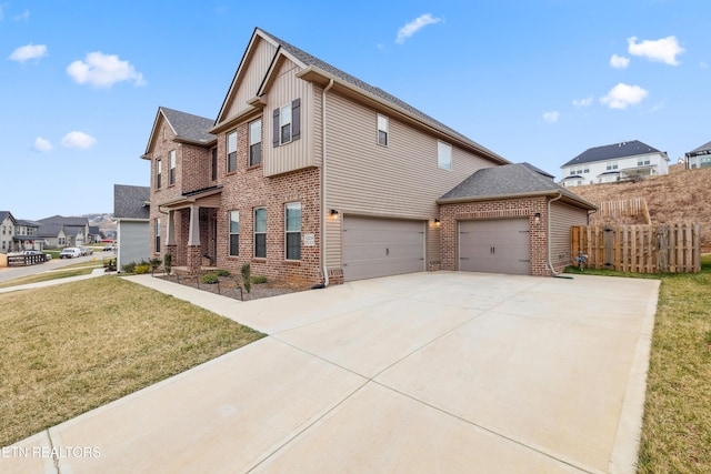 traditional-style house with brick siding, driveway, a front lawn, and fence