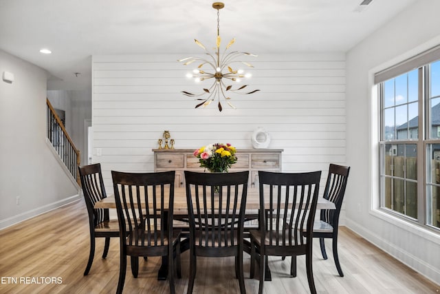 dining space featuring recessed lighting, light wood-style floors, an inviting chandelier, baseboards, and stairs