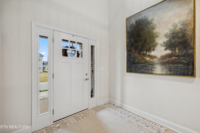 foyer entrance with baseboards and a healthy amount of sunlight