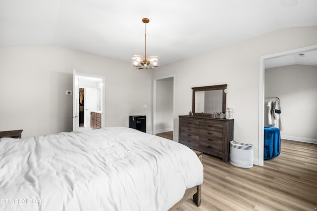 bedroom with baseboards, light wood finished floors, an inviting chandelier, and vaulted ceiling