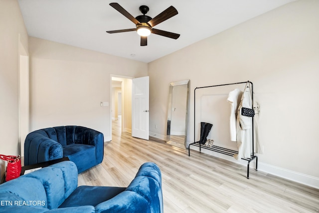 sitting room featuring baseboards, ceiling fan, and light wood finished floors