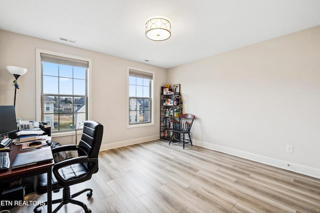 office featuring visible vents, plenty of natural light, baseboards, and light wood-type flooring