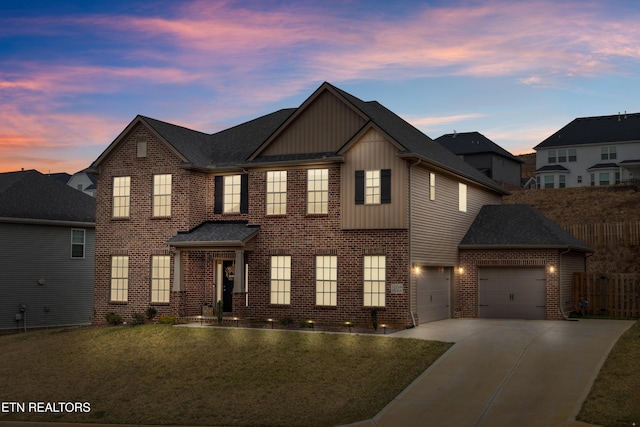 view of front facade featuring brick siding, a shingled roof, fence, concrete driveway, and a lawn