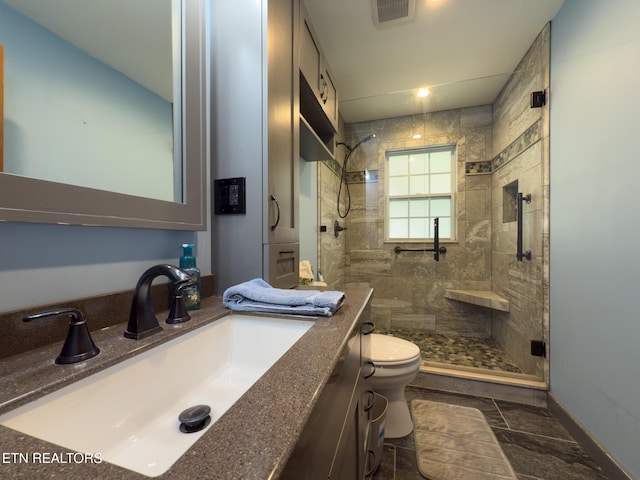 full bath featuring vanity, baseboards, visible vents, a stall shower, and toilet