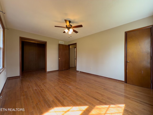 unfurnished bedroom featuring a closet, visible vents, light wood-type flooring, and baseboards