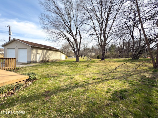 view of yard featuring a detached garage and an outbuilding