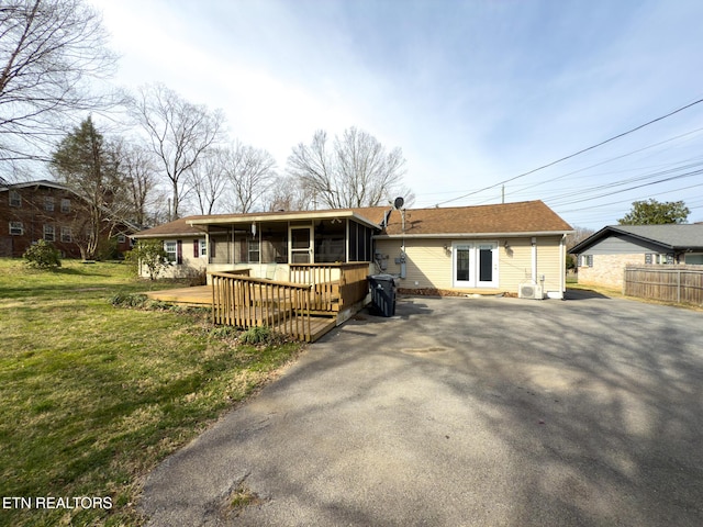 view of front of house with a front lawn and a sunroom