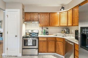 8836 Nubbin Ridge Rd, Knoxville, TN 37923 - kitchen with stainless steel appliances, range hood, and brown cabinetry