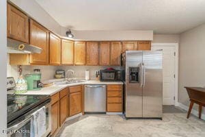 8836 Nubbin Ridge Rd, Knoxville, TN 37923 - kitchen with a sink, light countertops, appliances with stainless steel finishes, under cabinet range hood, and brown cabinets