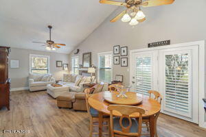 8836 Nubbin Ridge Rd, Knoxville, TN 37923 - dining room featuring ceiling fan, light wood finished floors, high vaulted ceiling, and baseboards