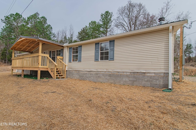 rear view of property featuring a wooden deck