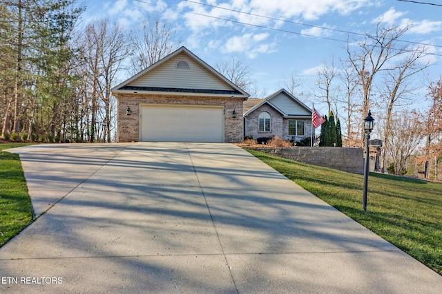 view of front facade with brick siding, a garage, a front lawn, and driveway