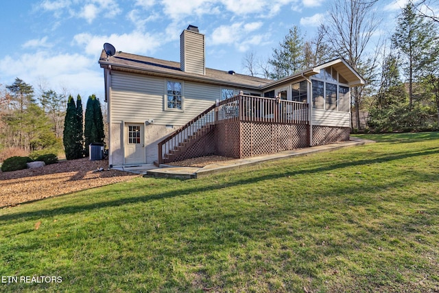 rear view of property featuring central air condition unit, a lawn, stairway, a wooden deck, and a chimney