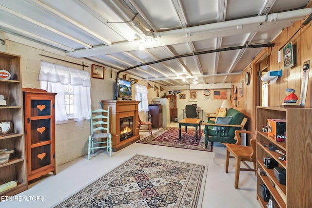 below grade area featuring a glass covered fireplace and concrete block wall