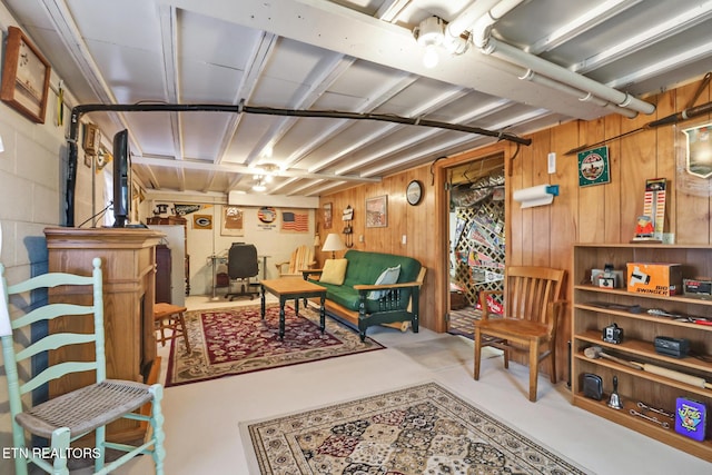 living area featuring wood walls and concrete block wall