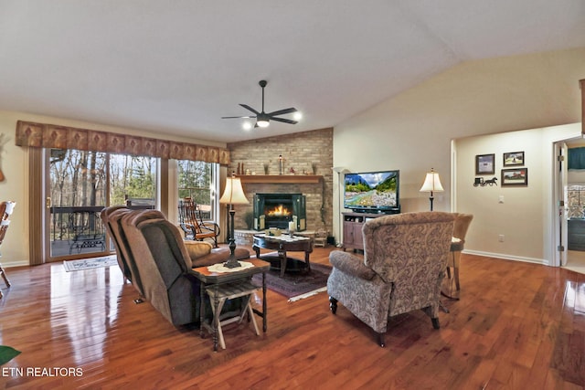 living area with lofted ceiling, a brick fireplace, wood finished floors, and ceiling fan