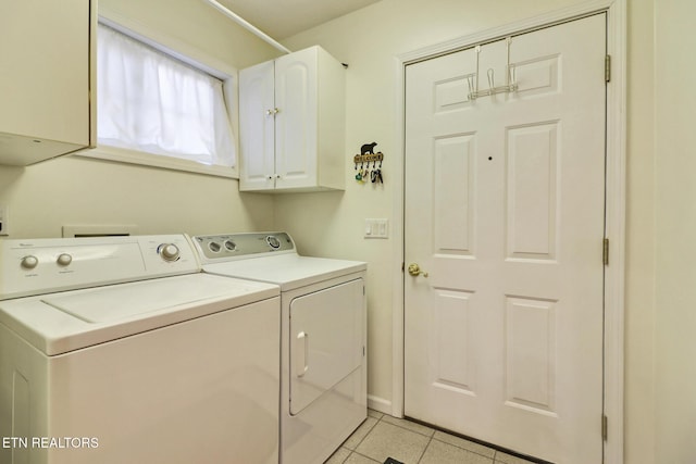 washroom featuring washing machine and clothes dryer, cabinet space, baseboards, and light tile patterned flooring