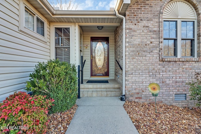 view of exterior entry with brick siding