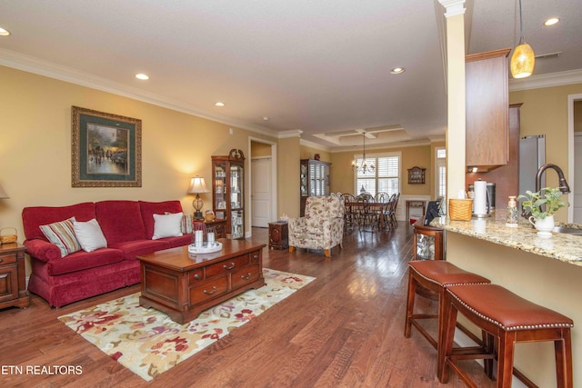 living room with a chandelier, recessed lighting, crown molding, and dark wood-type flooring