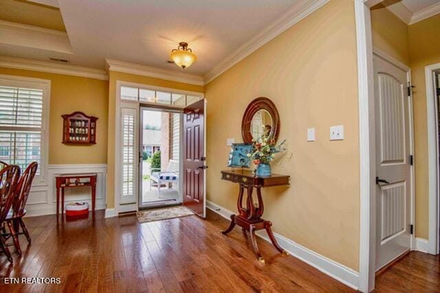 foyer entrance with wood-type flooring, baseboards, ornamental molding, and plenty of natural light