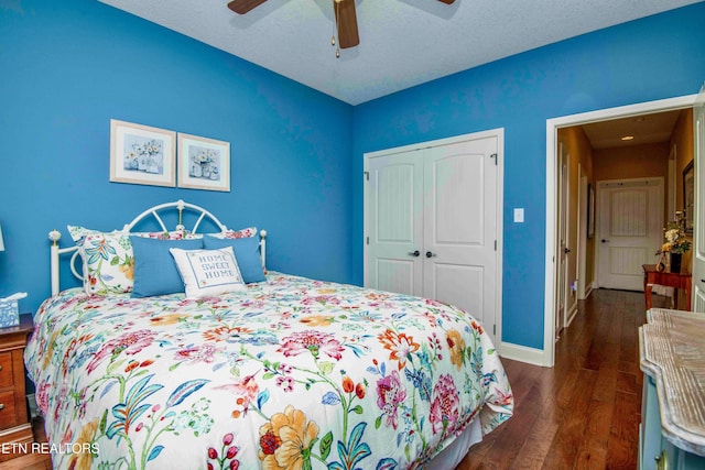 bedroom with dark wood finished floors, a closet, a ceiling fan, and baseboards