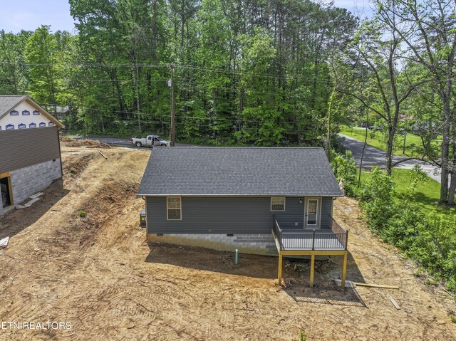 exterior space featuring a shingled roof, a wooden deck, and crawl space