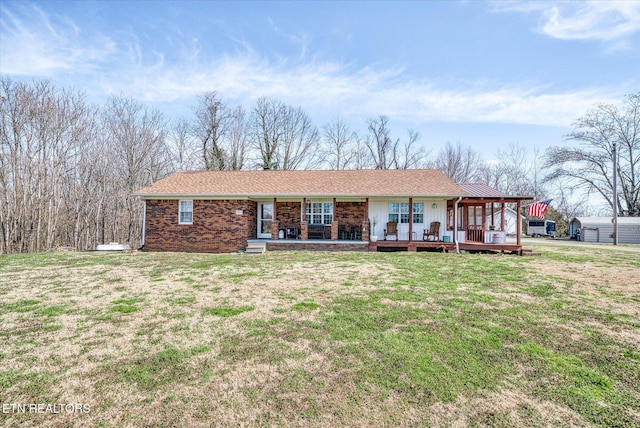 ranch-style house featuring covered porch and a front yard